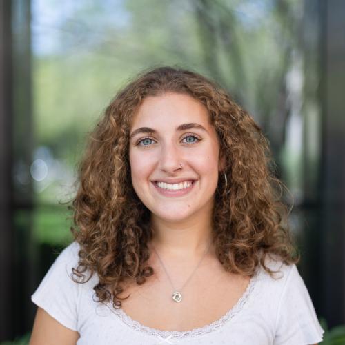A portrait of a young woman with curly dark-blond hair.