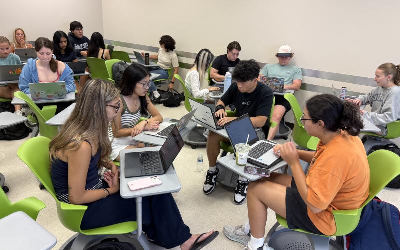 Students in groups working on laptops
